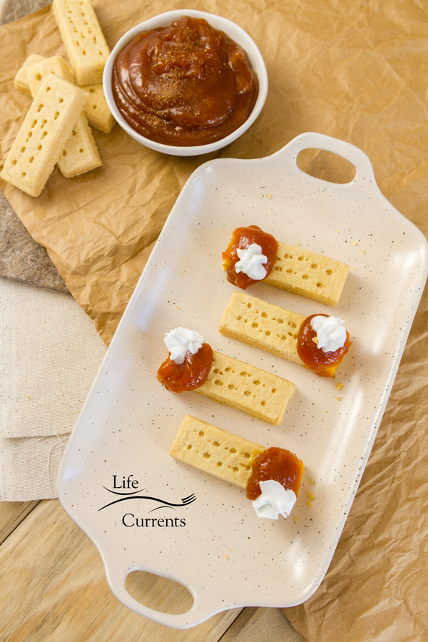 A tray full of Pumpkin Butter pie bites with a bowl of pumpkin butter and shortbread cookies on the side 