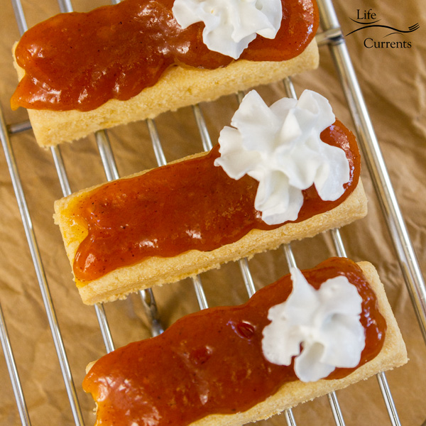 Pumpkin Pie Bites with whipped cream on a cooling rack, square image 