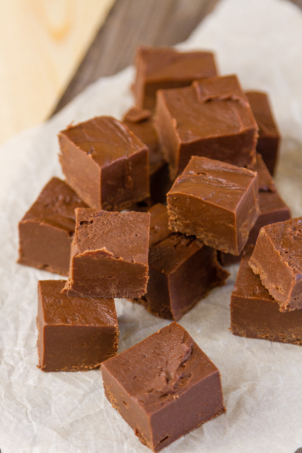 Rich smooth and creamy Mocha Fudge with the intense flavor of espresso and chocolate. This is a fudge that deserves a special place in your holiday baking and gift giving. a arge pile of deicious mocha fudge on parchment paper