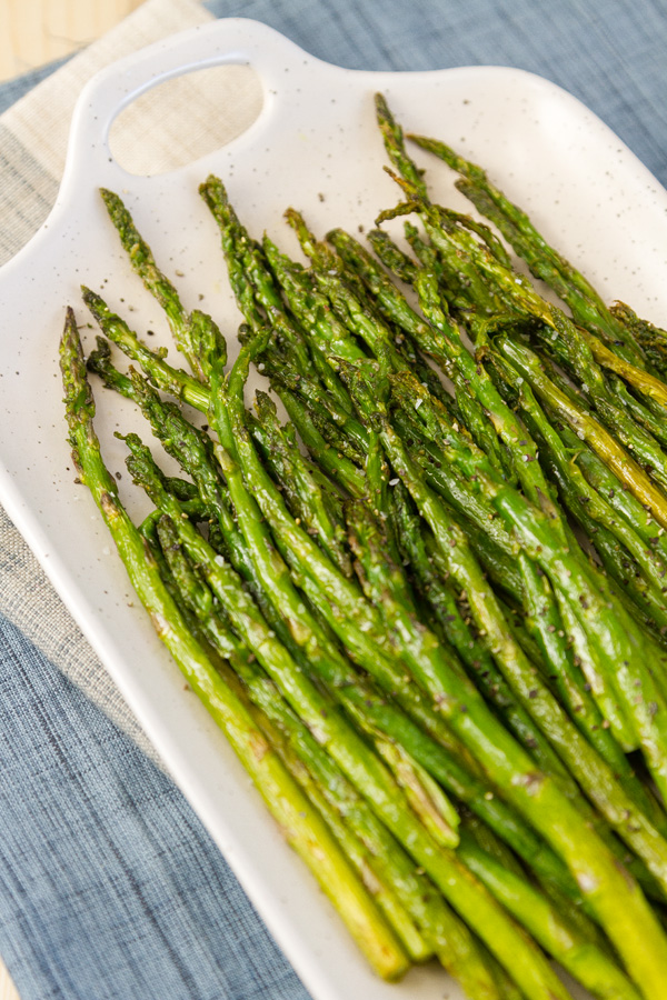Air Fryer Asparagus - Roasted asparagus is so tender and flavorful. So I thought I’d share how to air fry it – just a nice simple easy to make recipe. asparagus on a white platter