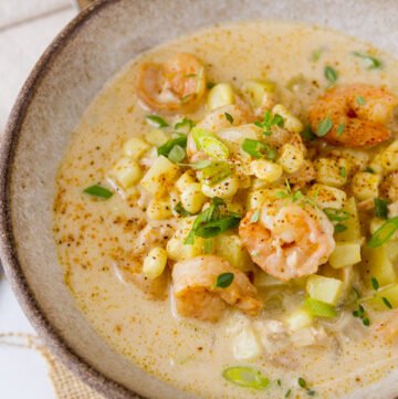 a white bowl with a spoon to serve Cajun Seafood chowder