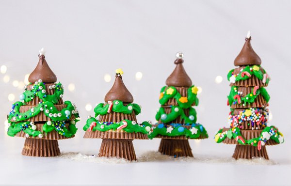 4 Chrismas trees made from peanut butter cups standing next to each other 