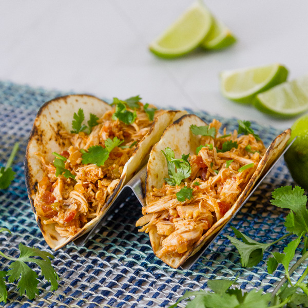 square crop of two chicken tacos with guacamole