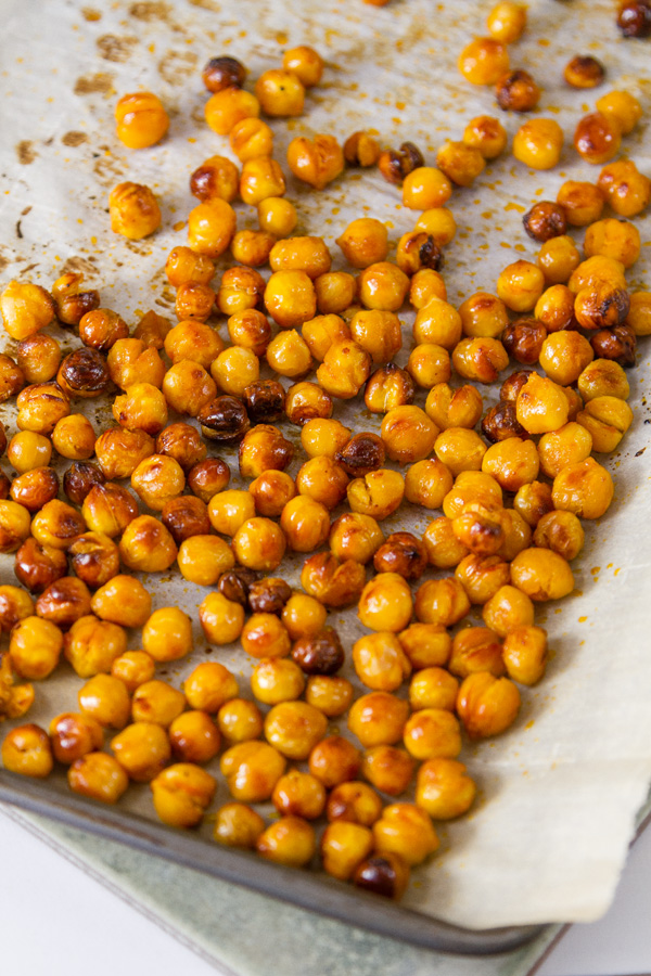 Buffalo Roasted Chickpeas on parchment paper in a rimmed baking sheet