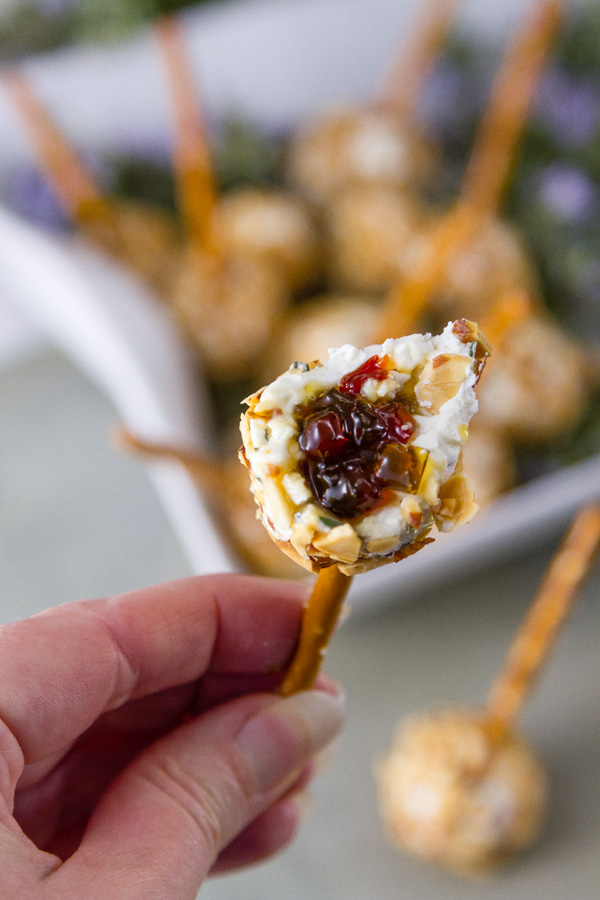 a bite taken out of a Pepper Jelly Cheese Balls so you can see the surprise inside 