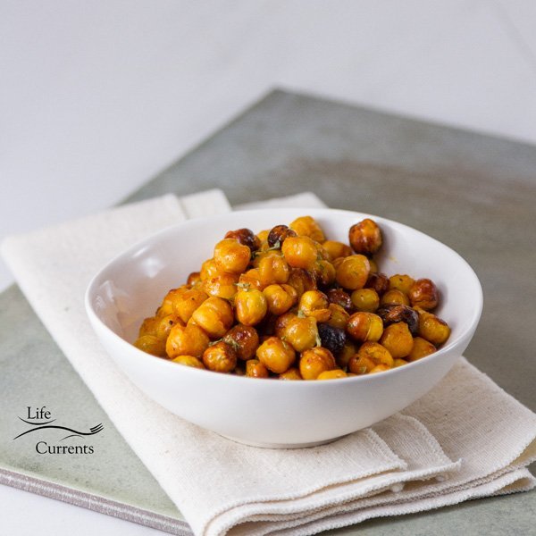 Square crop of Buffalo Roasted Chickpeas in a white bowl on a grey background