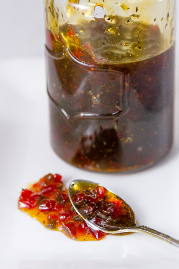 The pepper jelly used in Pepper Jelly Cheese Balls with a spoonful in the front of the image