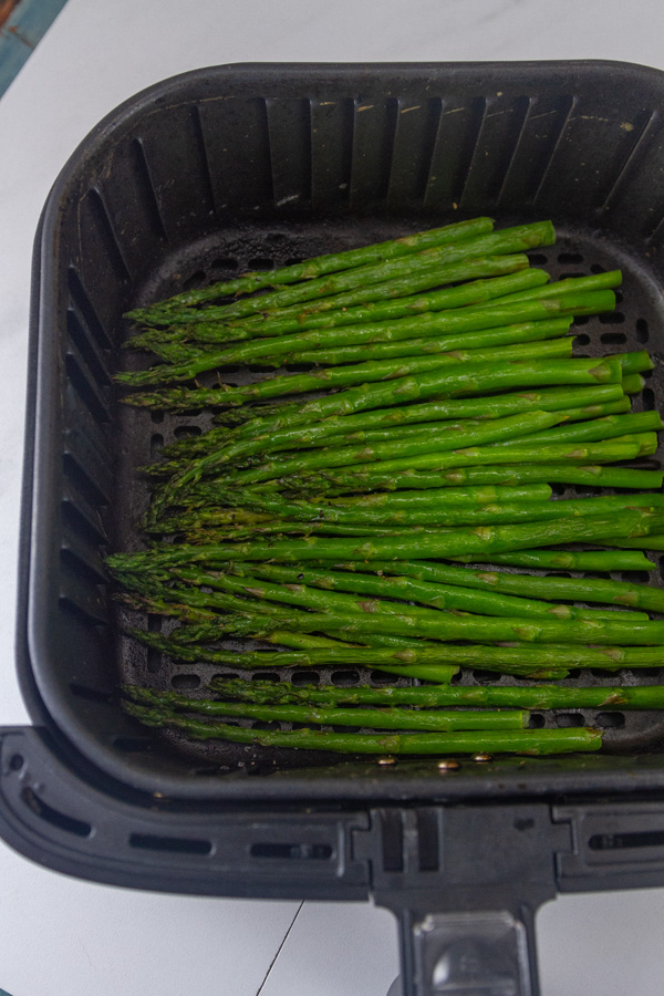 asparagus in the basket of an air fryer.