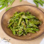 cooked pea pods on a brown plate.