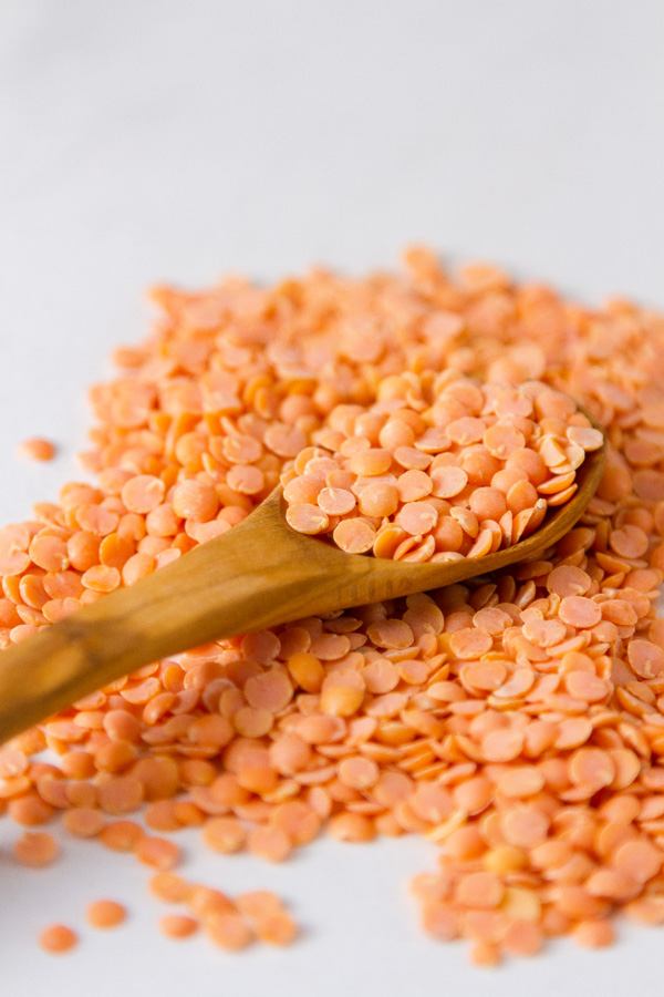 red lentils for Red Lentil and Artichoke Stew with a wooden spoon