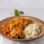 Red Lentil and Artichoke Stew with brwon rice in a brown bowl