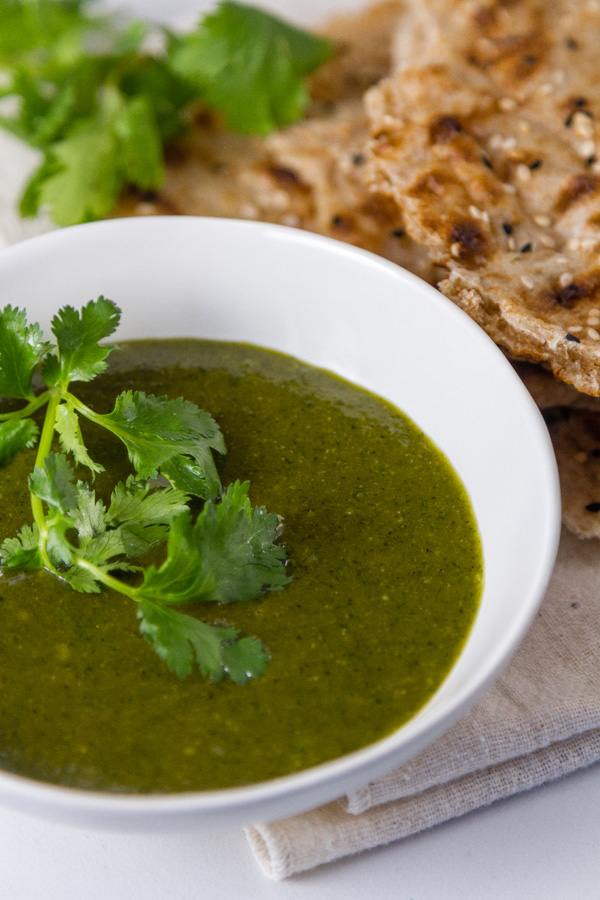 Tamarind Cashew Dipping Sauce  in a white bowl with sangak bread and cilantro in the background 