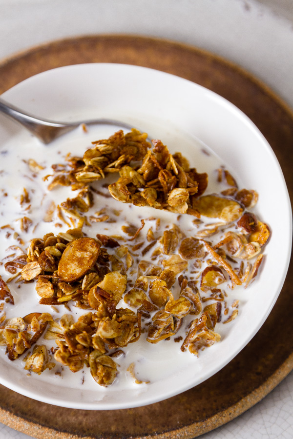 Homemade Granola Recipe served with milk in a white bowl