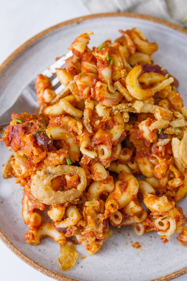 a serving of chili mac on a white plate with a fork