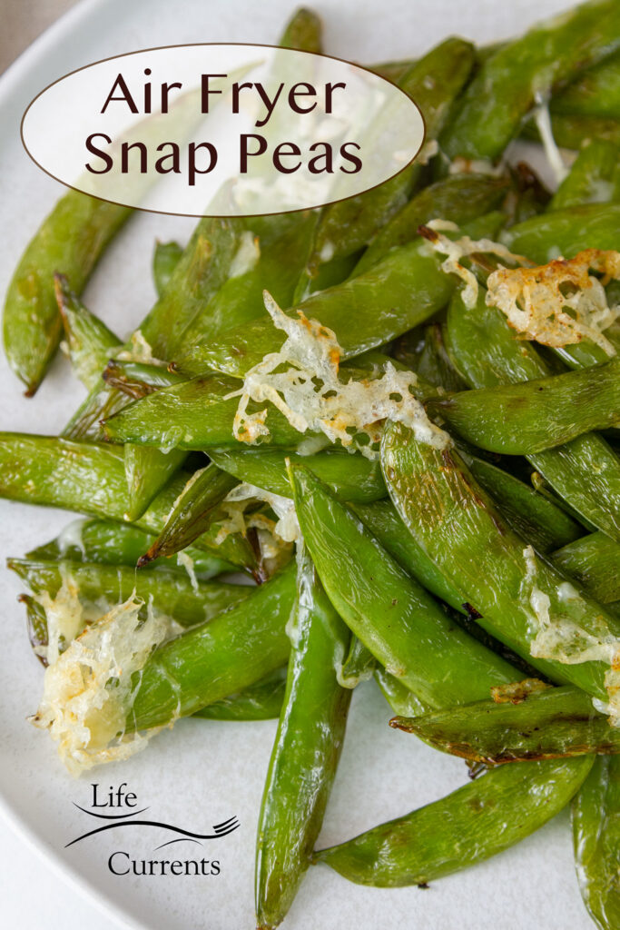 cooked snap peans with some Parmesan cheese on a white plate, title on upper left: Air Fryer Snap Peas.