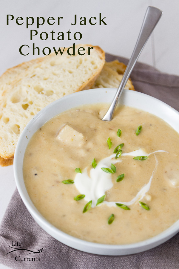 Rich and creamy, perfect comfort food. This Pepper Jack Potato Soup (or is it a chowder?) is so good and so easy to make. This is one your family will ask for again and again. A bowl of Pepper Jack Potato Soup in a white bowl with a grey napkin, spoon in the bowl, and some bread. Title on image