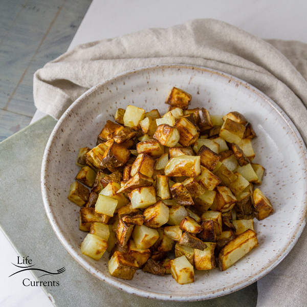 square crop of Air Fryer Potatoes in a white bowl 