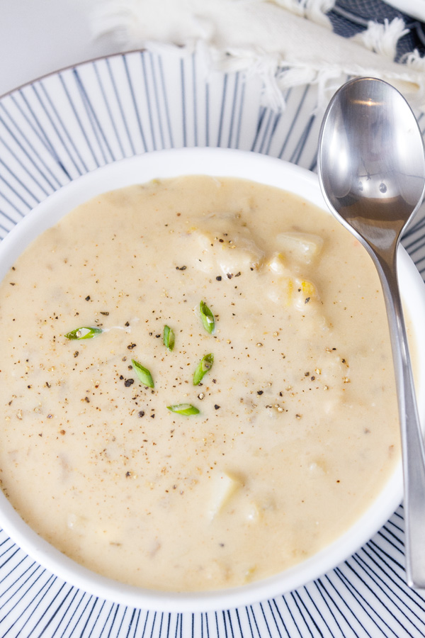 Rich and creamy, perfect comfort food. This Pepper Jack Potato Soup (or is it a chowder?) is so good and so easy to make. This is one your family will ask for again and again. A bowl of Pepper Jack Potato Soup with a spoon on a blue stipped plate