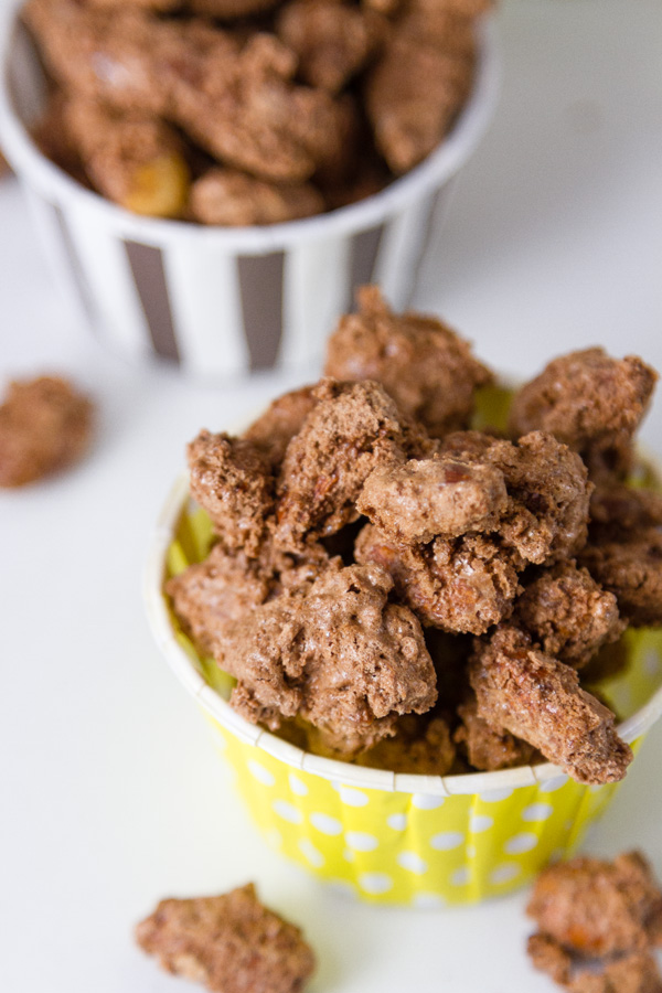 two nut cups filled with Mocha Candied Almonds and some spilled out 