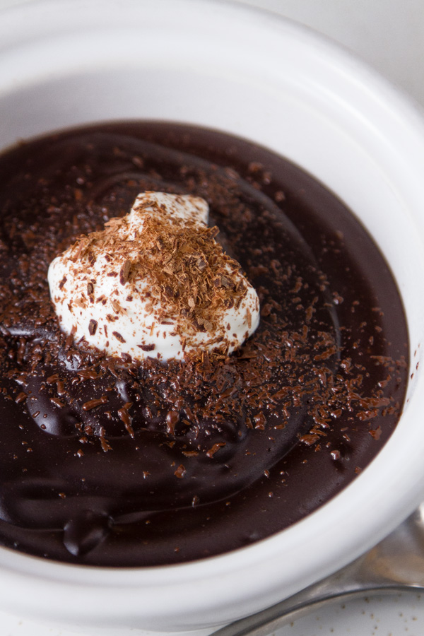 Chocolate Pudding in a white bowl with whipped cream and chocolate shavings 
