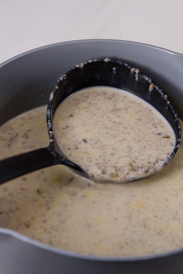 Copycat Souplantation Vegetarian Cream of Mushroom Soup in th epot being served up with a black ladle 