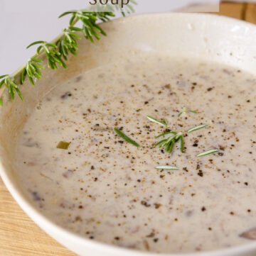 A white bowl filled with Copycat Souplantation Vegetarian Cream of Mushroom Soup a sprig of rosemary in the upper left and the title on top