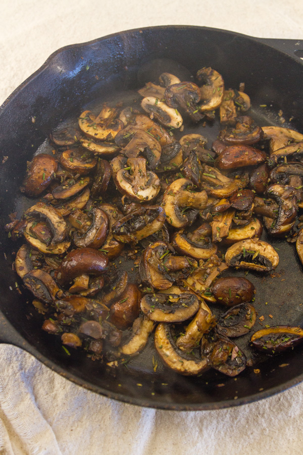 freshly cooked mushrooms in sauce in a cast iron skillet