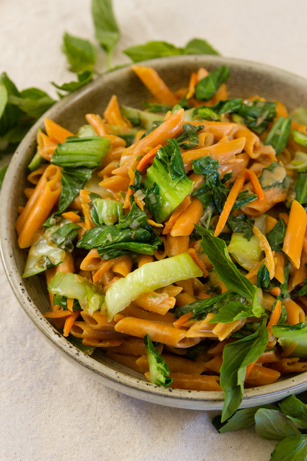 pasta and veggies in a bowl with fresh Thai Basil around it 