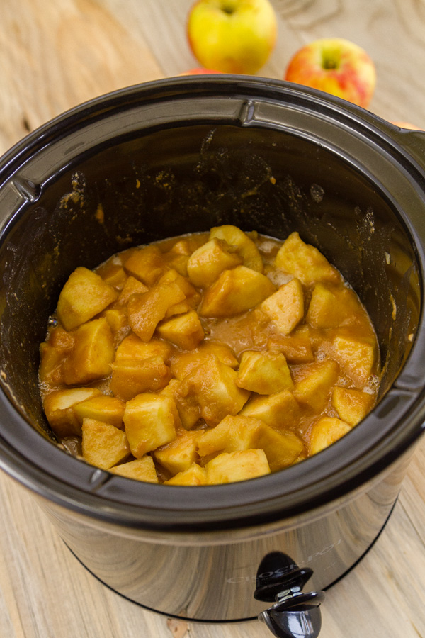 looking into the bowl of the crock pot at the cooked apples in sauce 