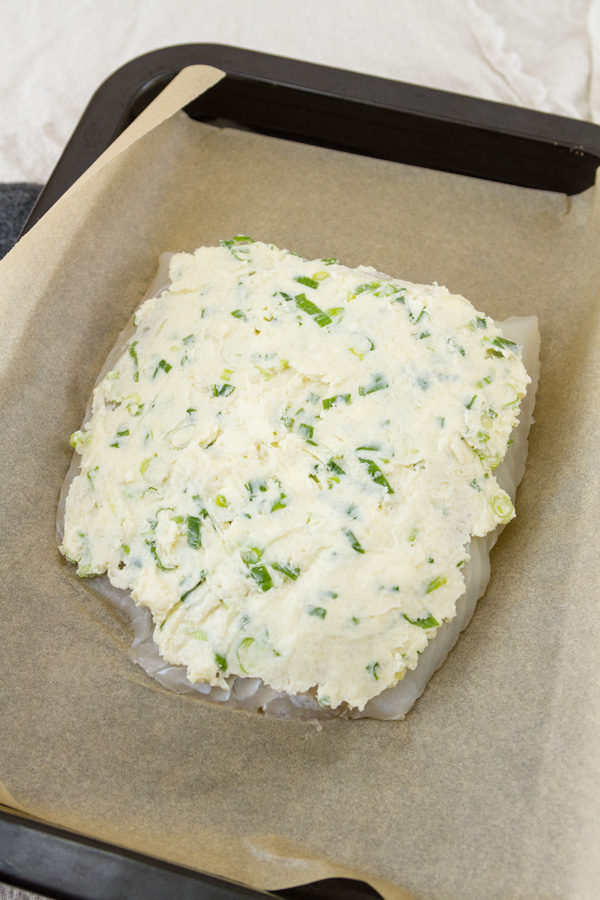 Parmesan mixture spread on the large piece of halibut