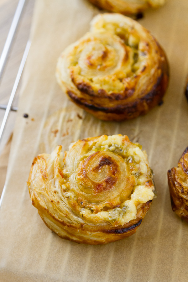 pinwheel appetizers cooling on a wire rack with parchment paper underneath 