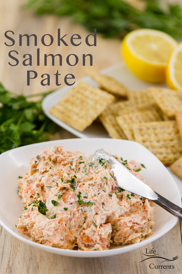 Title on image: Smoked Salmon Pate with the spread in a white dish with a knife served with crackers, lemons, and fresh parsley