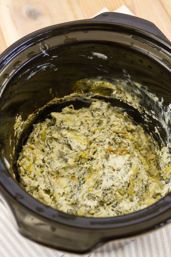 looking down into the bowl of the crock pot at the spinach dip