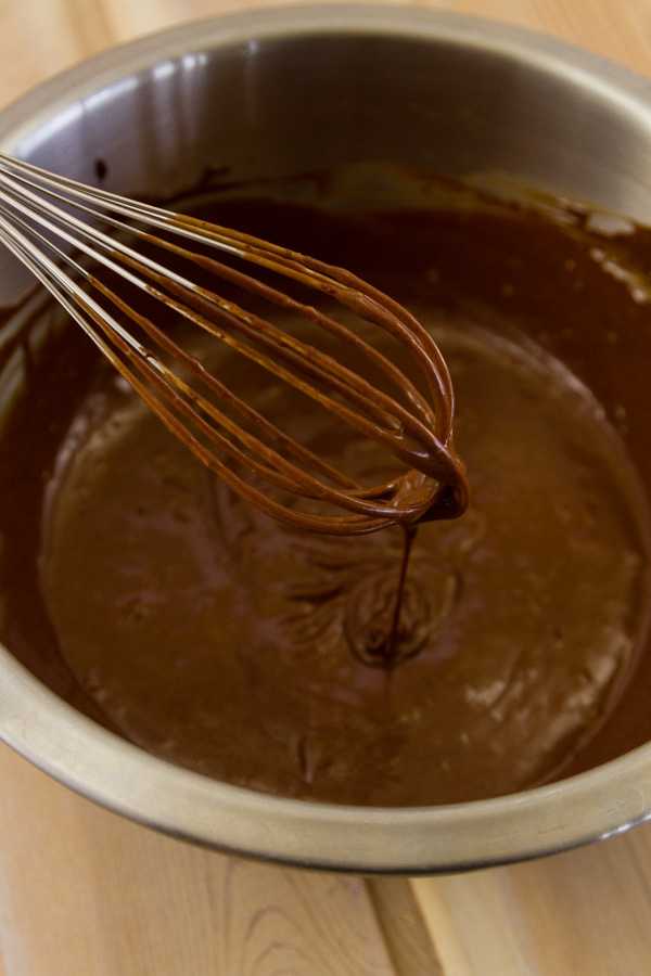 melted chocolate mixed with eggs, Kahlua , and coffee in a metal bowl with a wire whisk