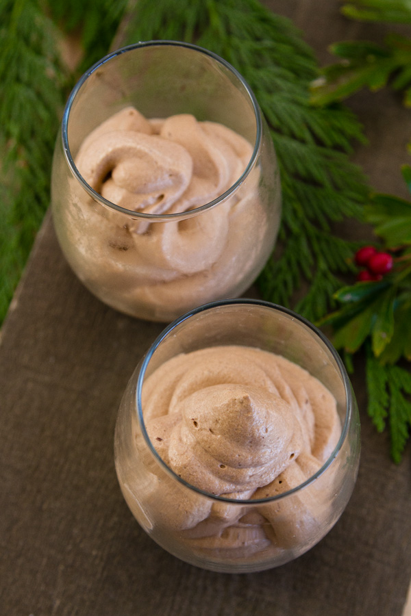 simple mousse served in glasses on a wood background with Christmas greens behind