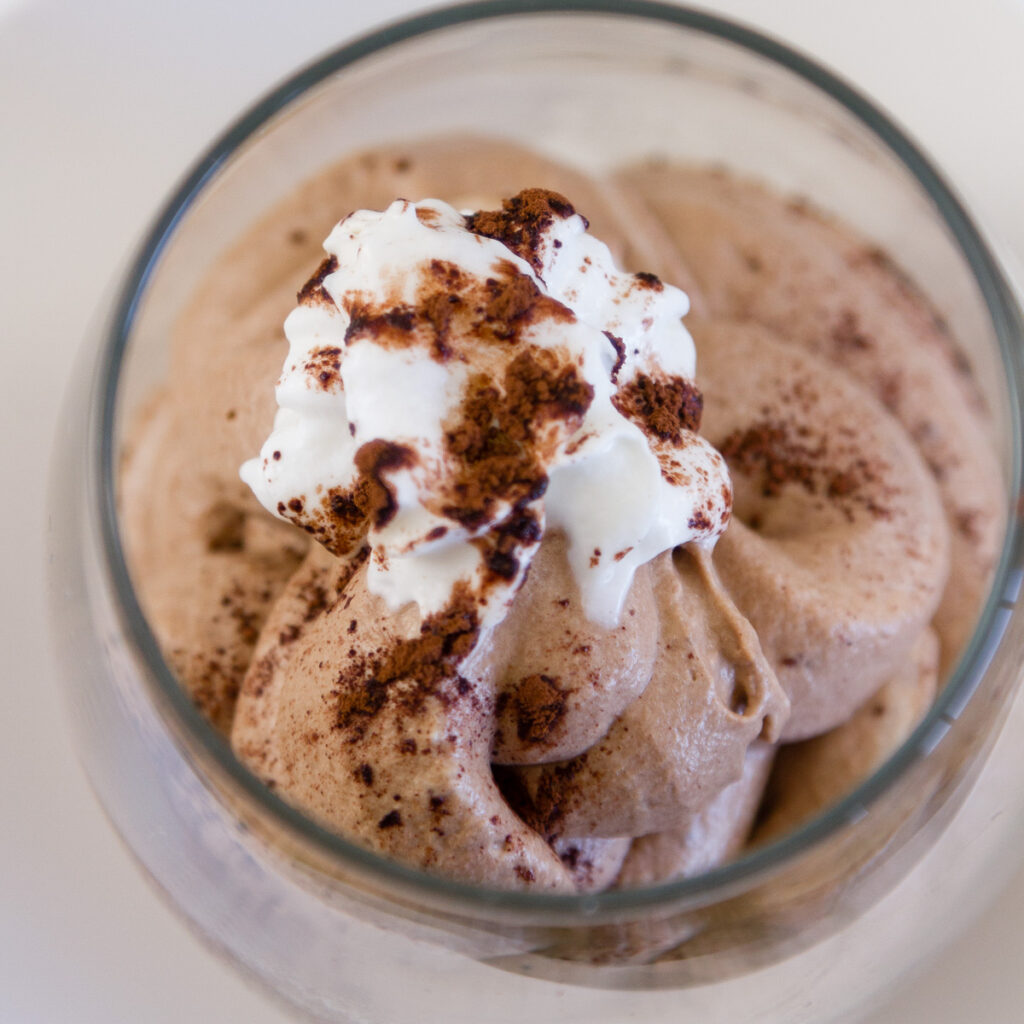 close up on Chocolate Mousse with whipped cream and cocoa powder