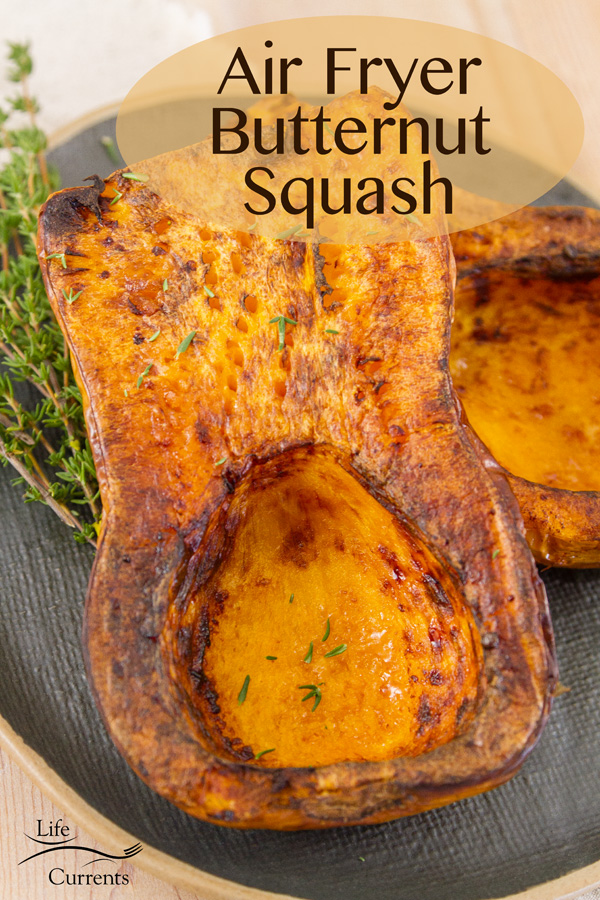 Cooked Air Fryer Butternut Squash on a dark plate with thyme sprigs and title on image