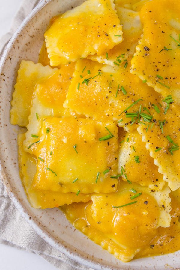 ravioli with carrot soup for sauce, garnished with chopped chives