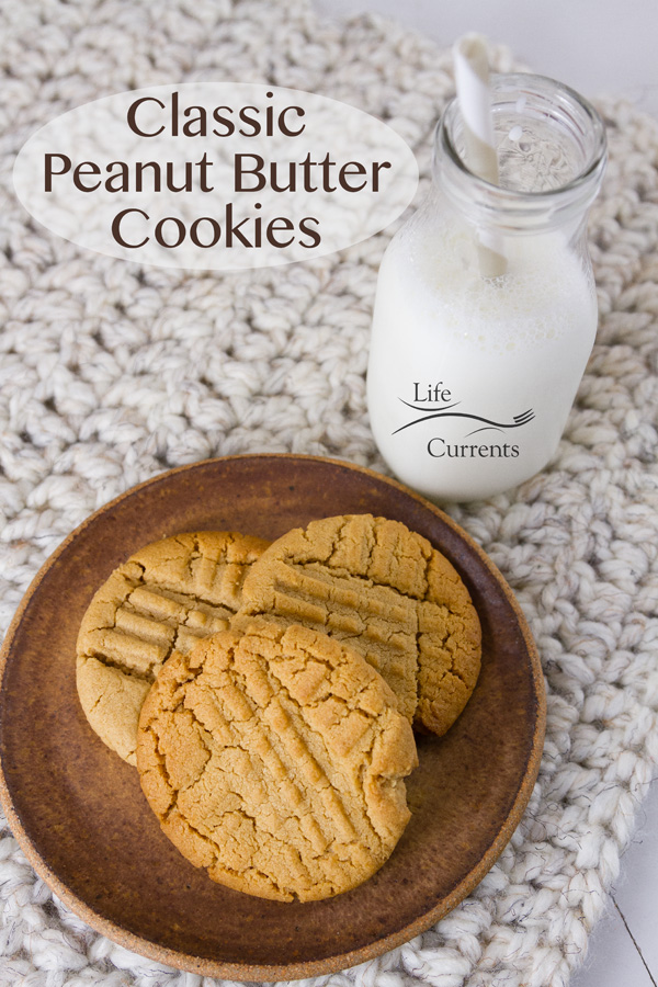 Classic Peanut Butter Cookies on a brown plate with a glass of milk, title on image