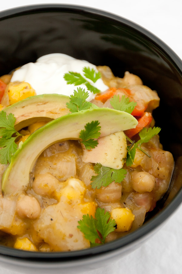 Vegetarian Stew in a black bowl with avocado and sour cream