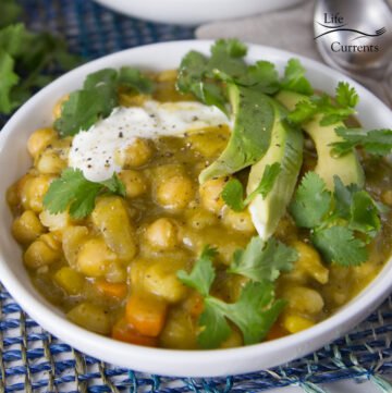 Vegetarian Chili Verde Stew in a white bowlwith avocado, sour cream, and cilantro