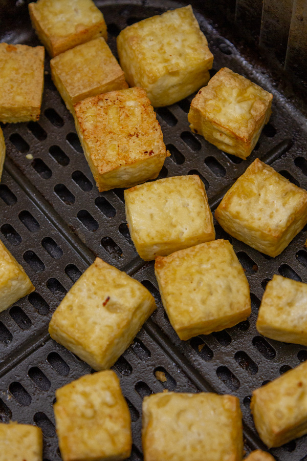 cooked tofu in an air fryer basket