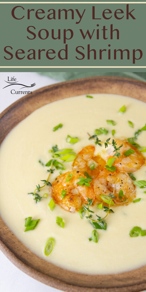 a brown bowl of leek soup with shrimp and herbs. Title on top: Creamy Leek Soup with seared shrimp