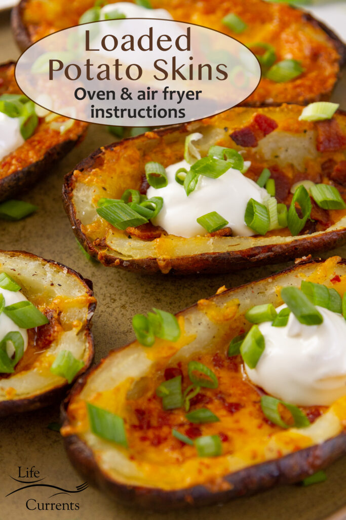Loaded potato skins with bacon, cheese, sour cream, and green onions on a plate.