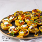 square crop of potato skins on a black serving tray.