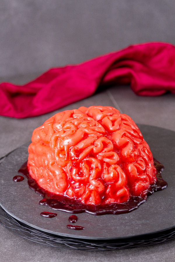 jello brain on a dark plate with a red silk scarf in the background