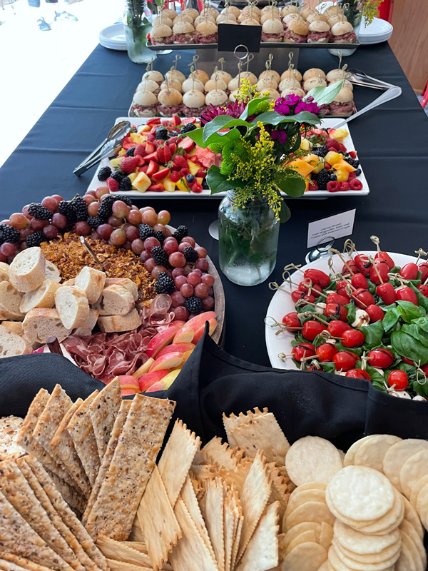 a catered event food spread on a black table cloth.