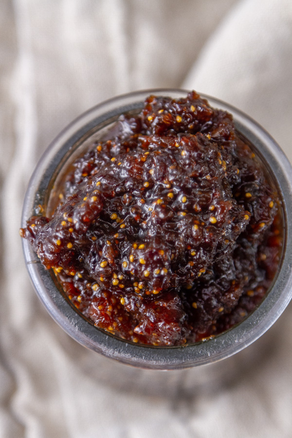 looking down into a glass jar willed with fig jam.