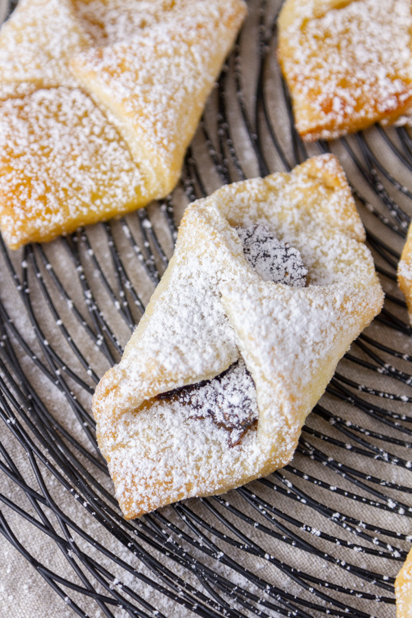 close up on a kolachy cookie filled with jam on a wire rack.