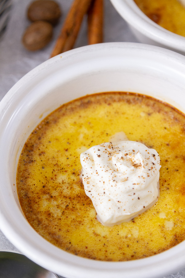 close up on a custard topped with whipped cream.